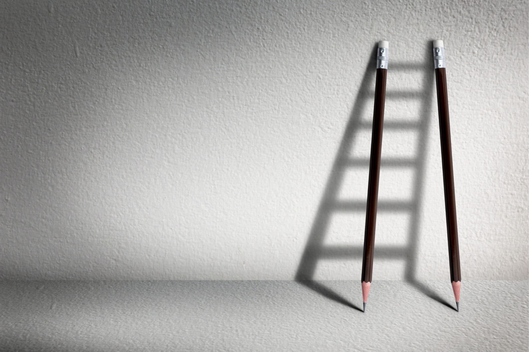 2 Pencils Lined up Against Wall